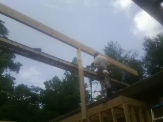 Carpenter setting a ridge beam over a new addition frame — Ice Dam Removal by Roofing Brothers in Dairy